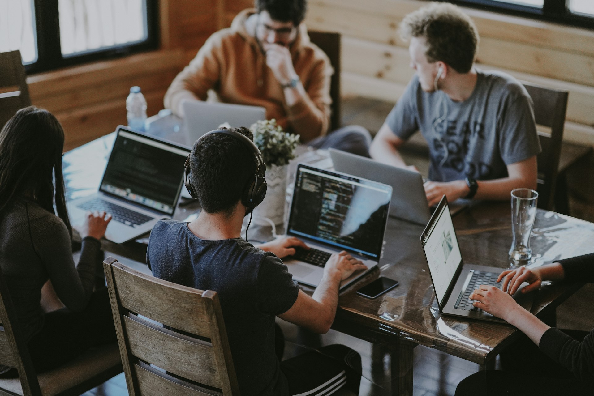 A team of developers working together at a table with laptops